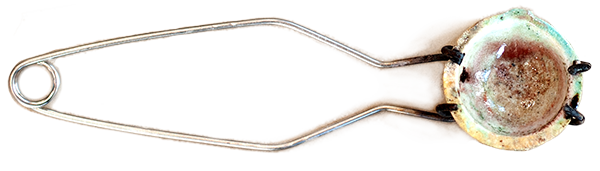 Close-up view of a metallic fuse with a ceramic or glass insulator at the base.