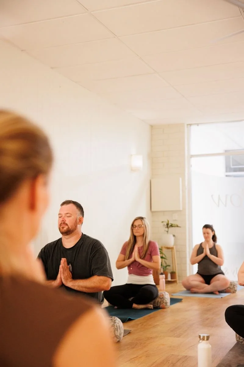 Quiet calm yoga class with students sat in meditation