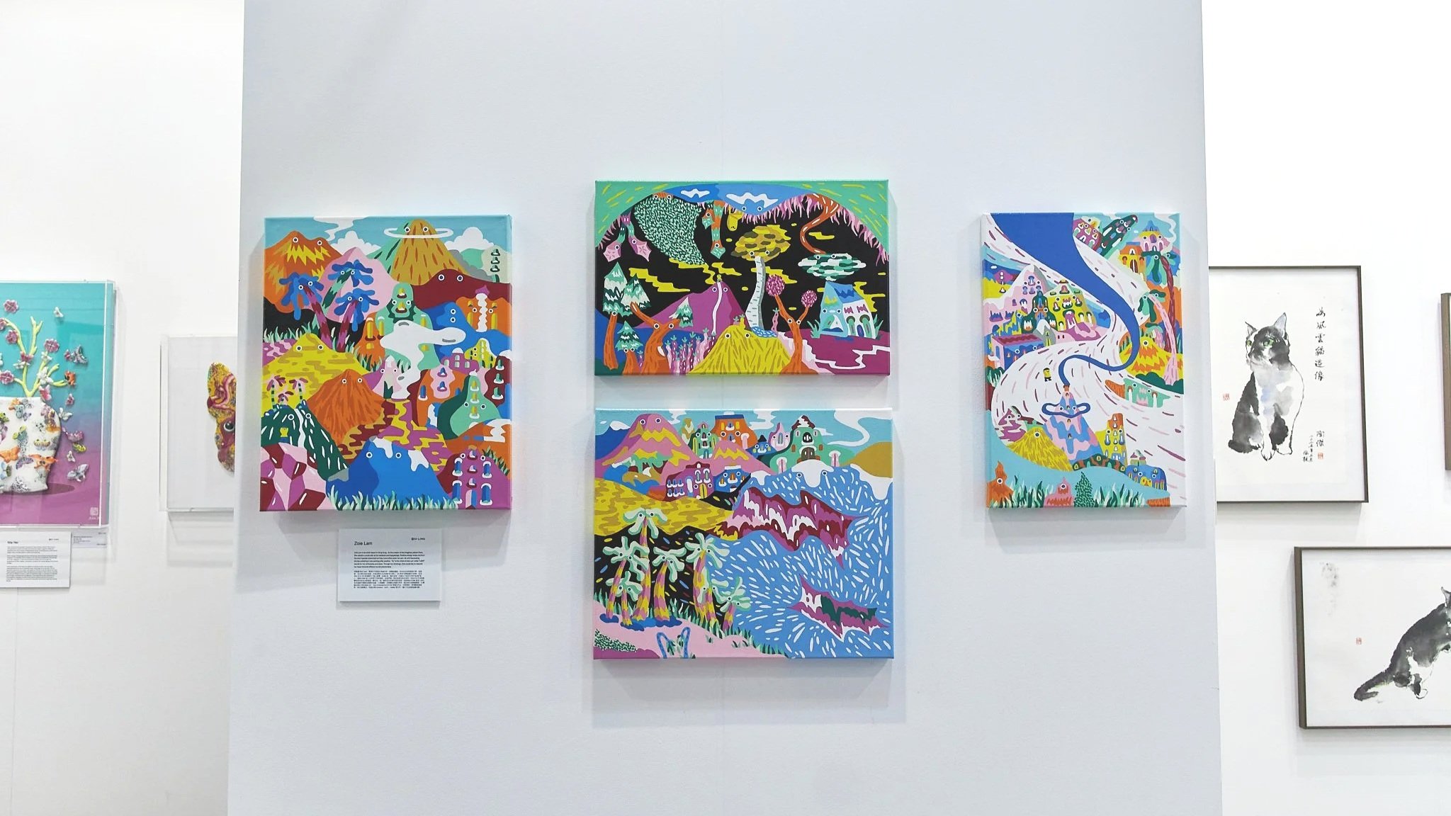 Art Central 2025: Colorful paintings of landscapes and imaginative scenes hung on a white gallery wall.