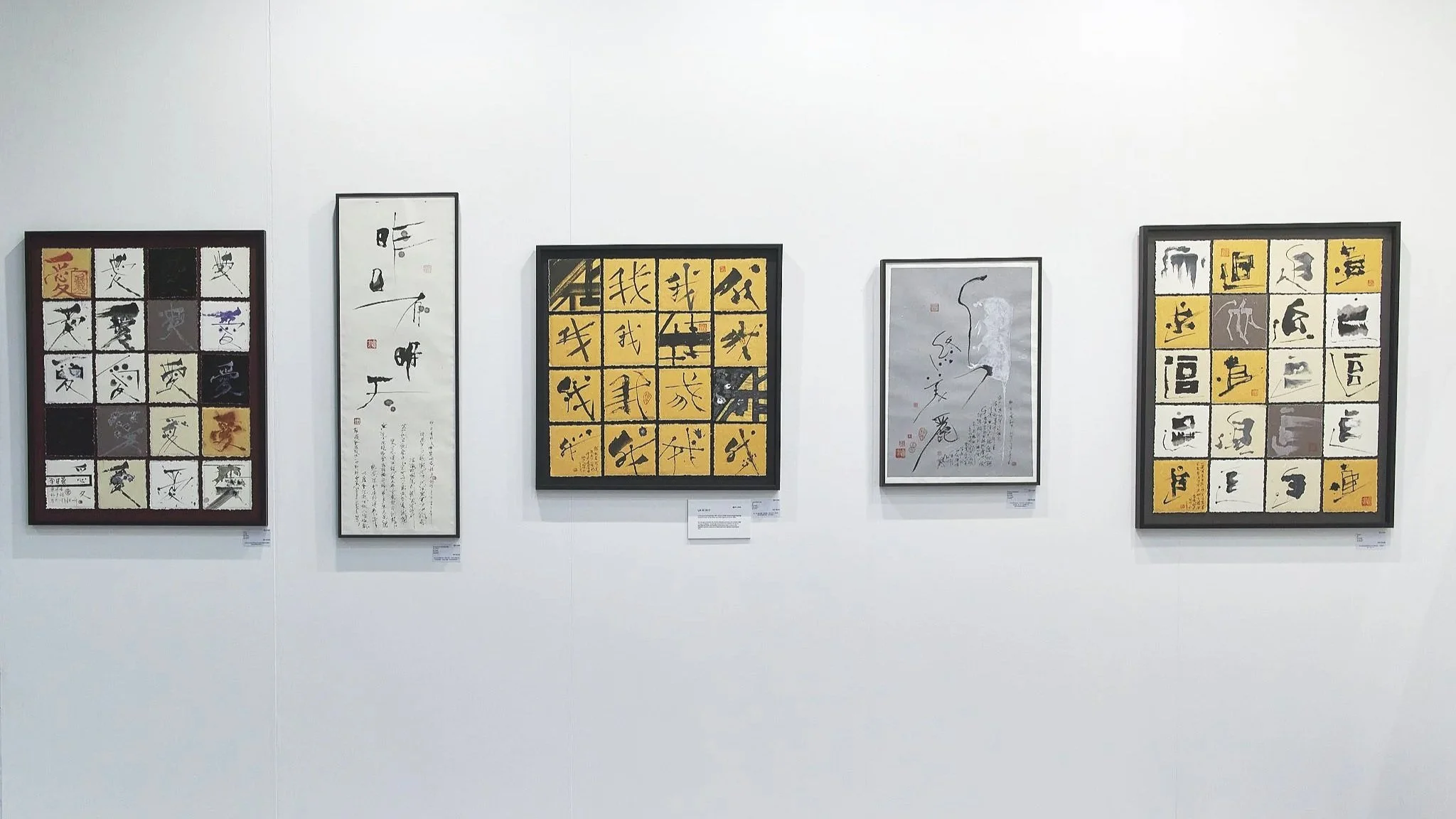 Art Central 2025: An art gallery wall displaying five framed pieces of Asian calligraphy and abstract art.
