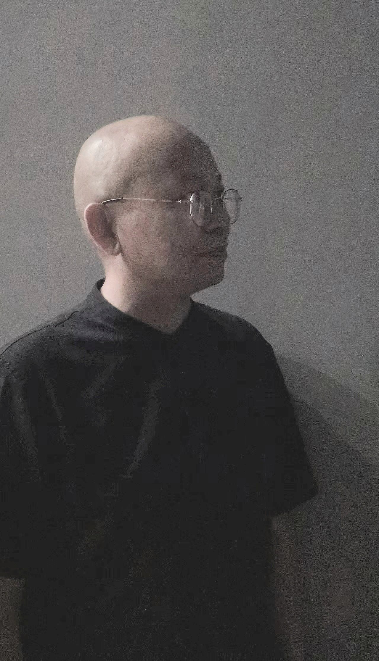Tian Yanhua 田言華：A bald person wearing glasses sitting by a window, looking outside thoughtfully.