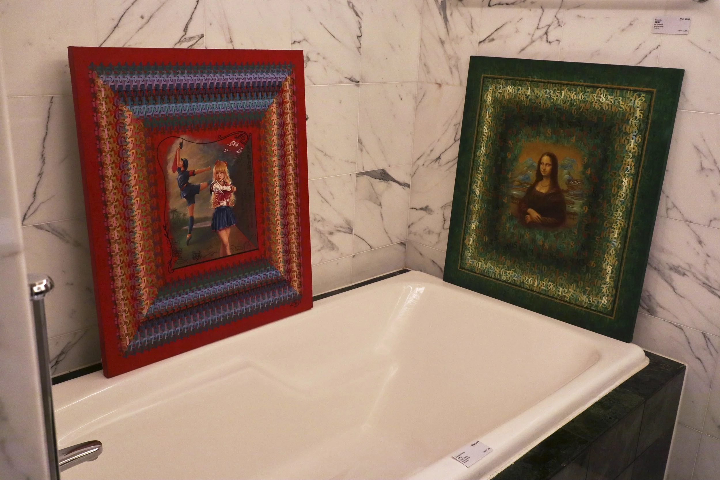 Two framed paintings on a marble-tiled wall behind a white bathtub. The left painting depicts a girl in a blue skirt and red sweater with a stick, and a girl in a school uniform. The right painting is a portrait of the Mona Lisa with a decorative bor