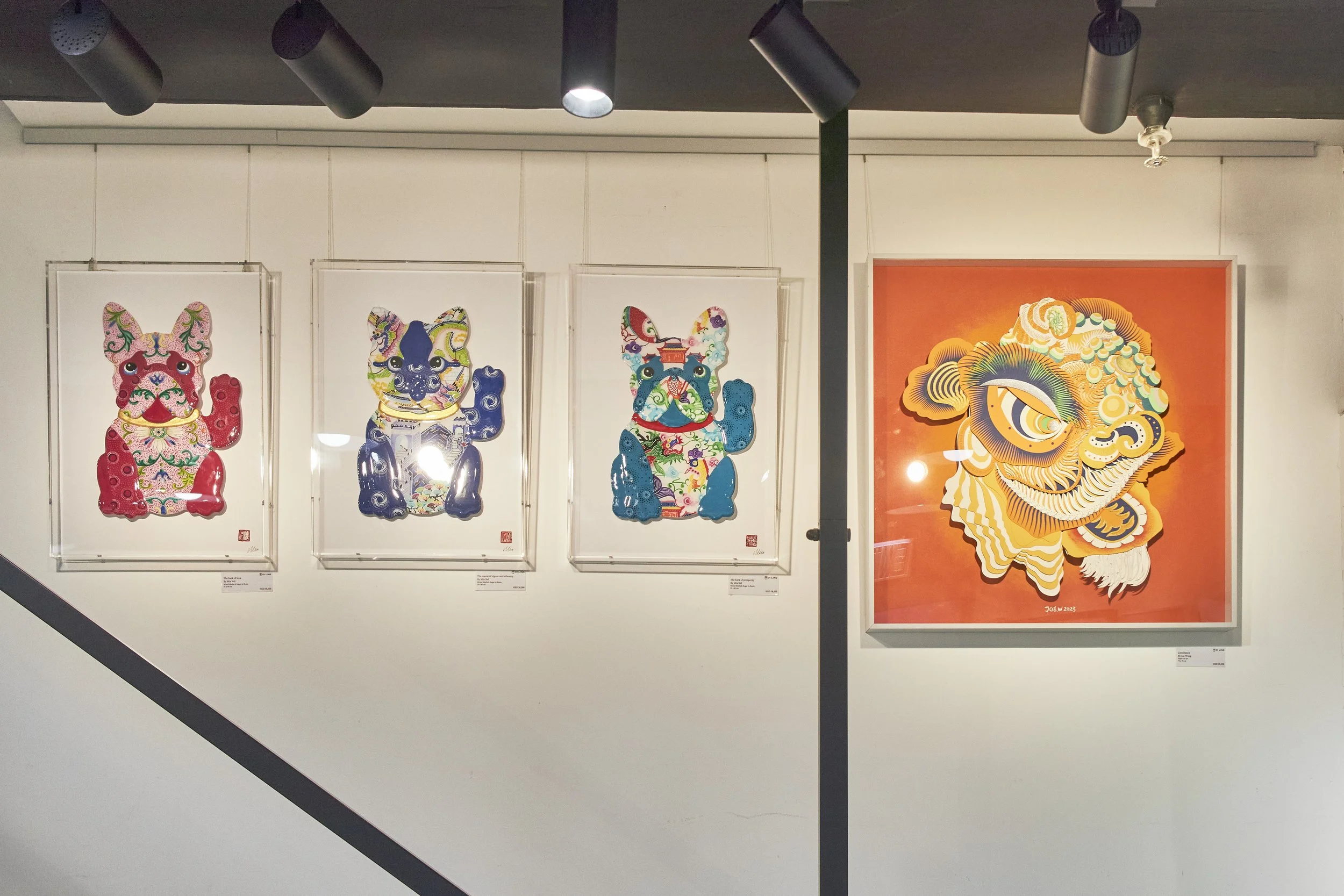 Gallery wall displaying four colorful art pieces featuring dog and lion motifs, with three framed dog images on the left and one large lion image on the right.