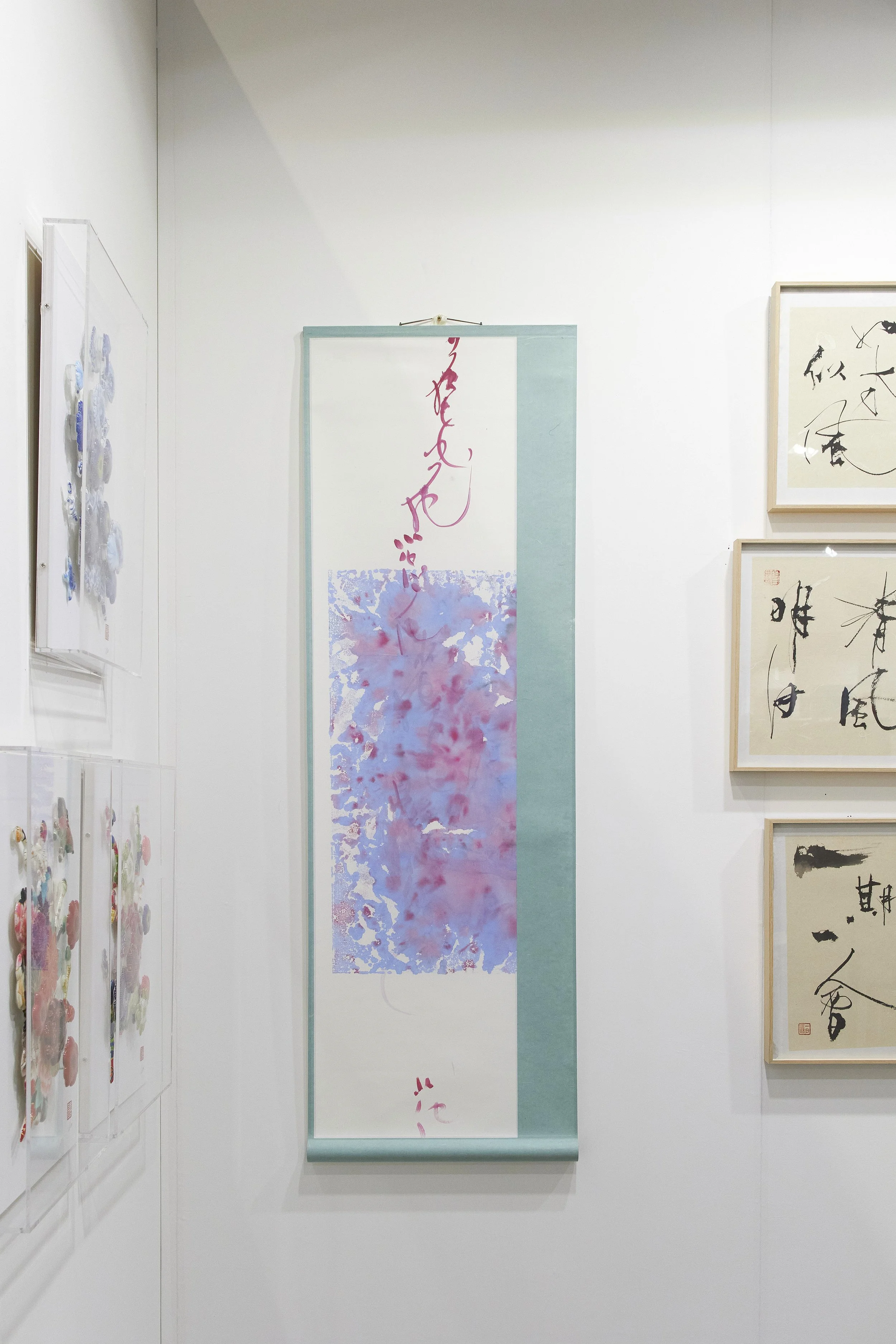 Affordable Art Fair 2025: Mixed media art gallery display featuring abstract and calligraphy artworks with pastel colors and ink brush strokes.