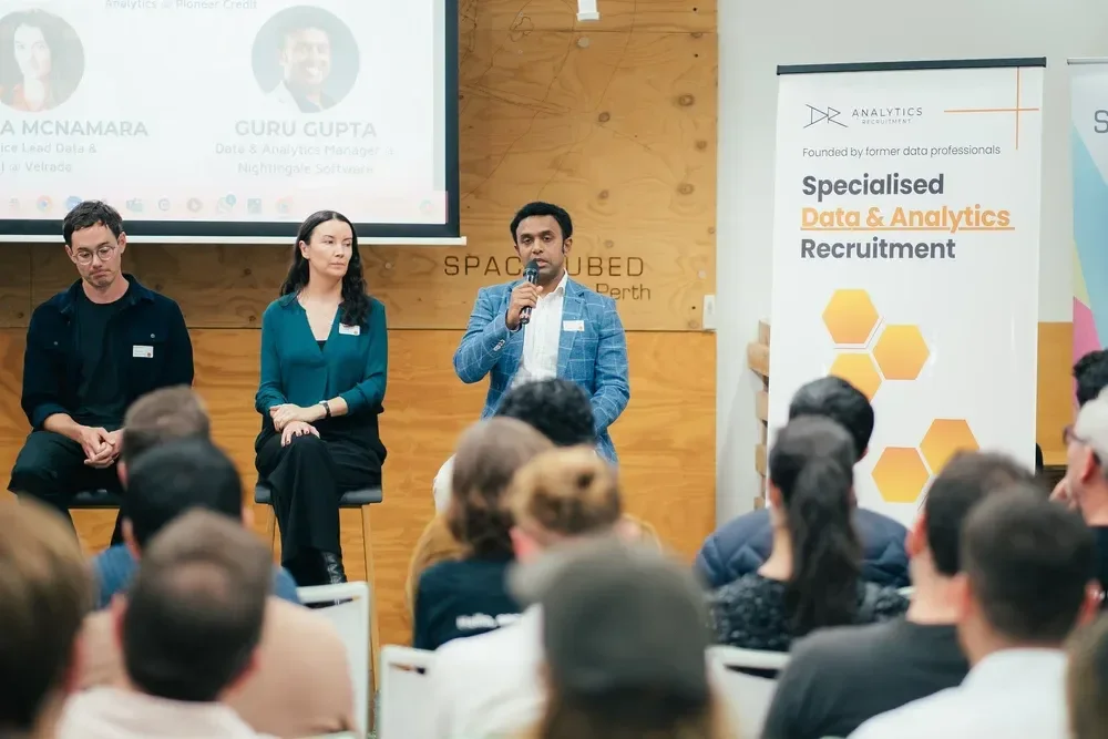 Speaking panel addressing crowd.