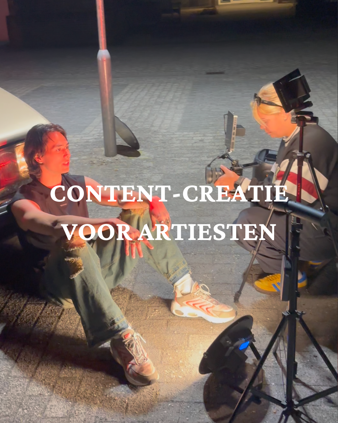 twee mensen, een muziek artiest en een videograaf staan in een behind the scenes setting buiten op shoot locatie met een camera sony a7iv en een lichten set-up content te maken