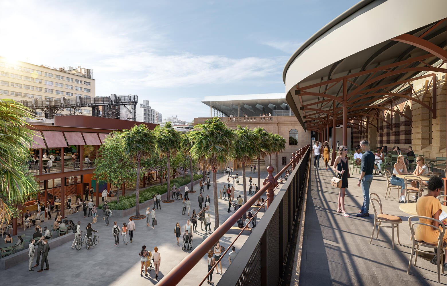 People walking, sitting, and socializing on a spacious outdoor terrace with palm trees, overlooking a lively city square with more pedestrians and cyclists below, on a clear day.