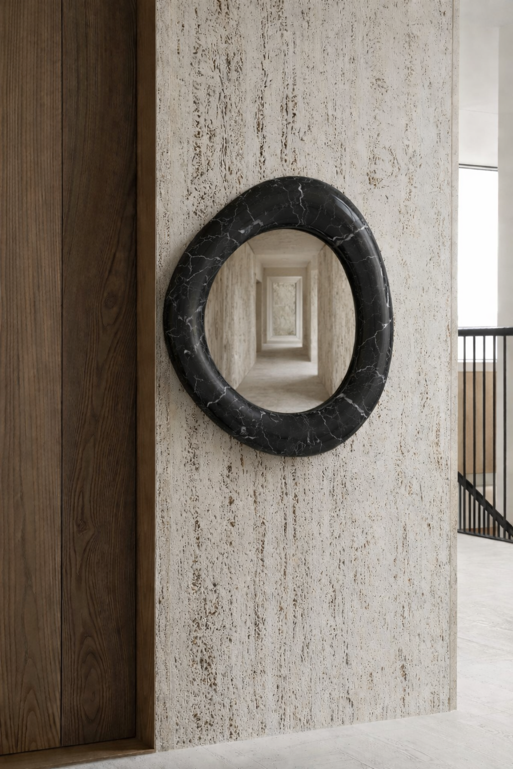 Sculptural mirror in matte black Marquina marble on travertine wall, luxury Italian interior design corridor