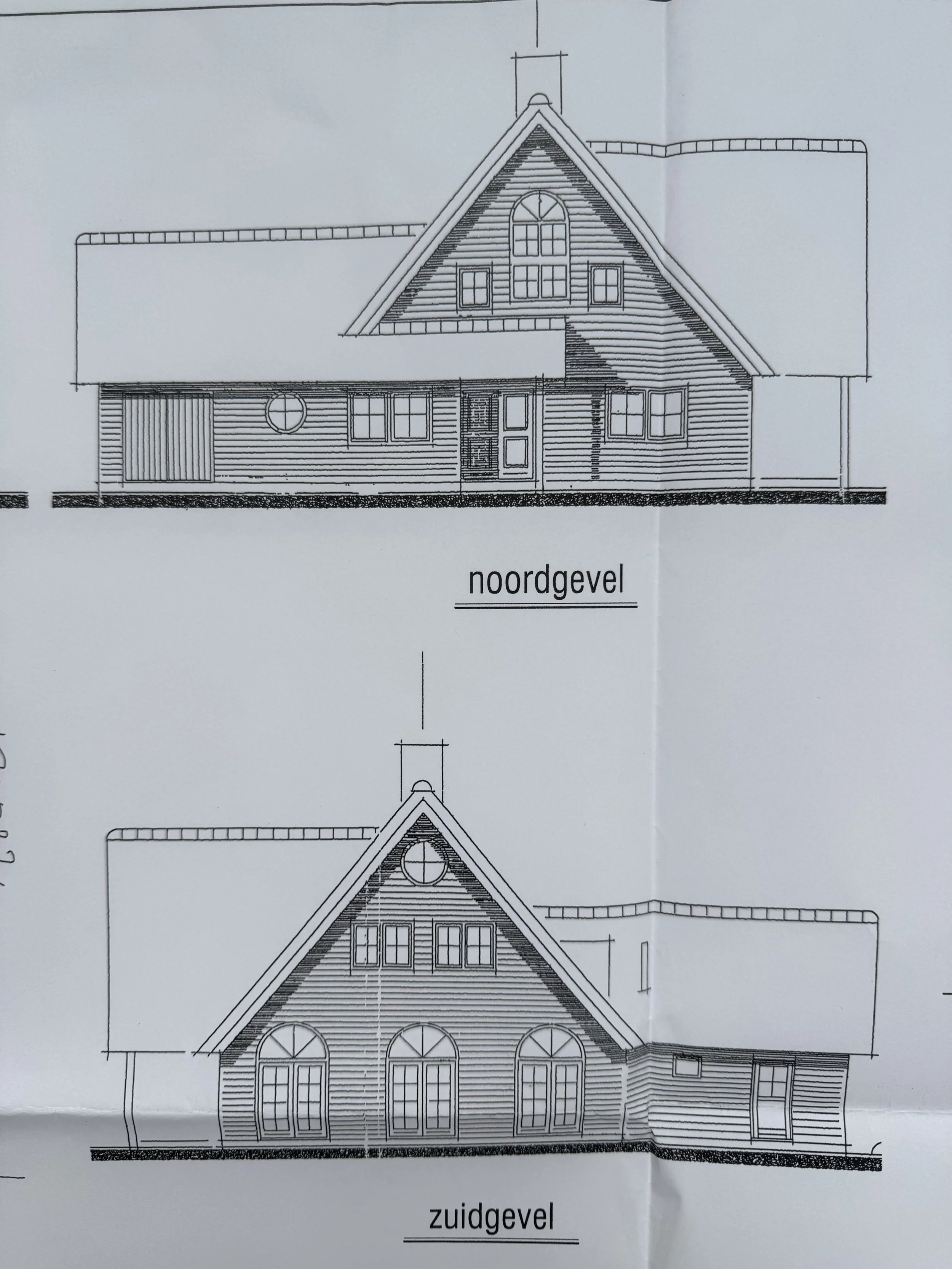 Blueprint drawings of a house, showing the north and south facades with detailed windows, doors, and rooflines.