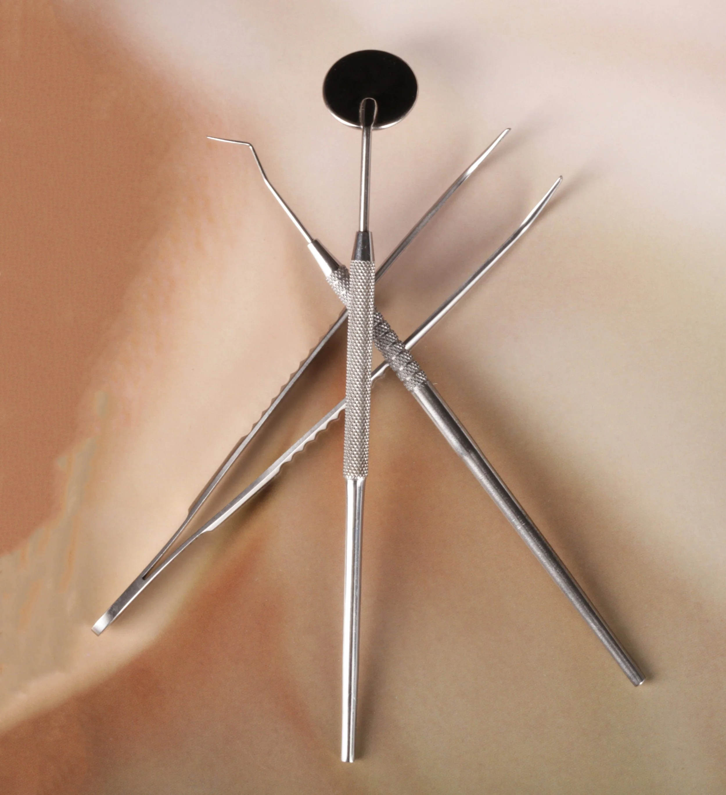 Dental tools arranged on a beige background.