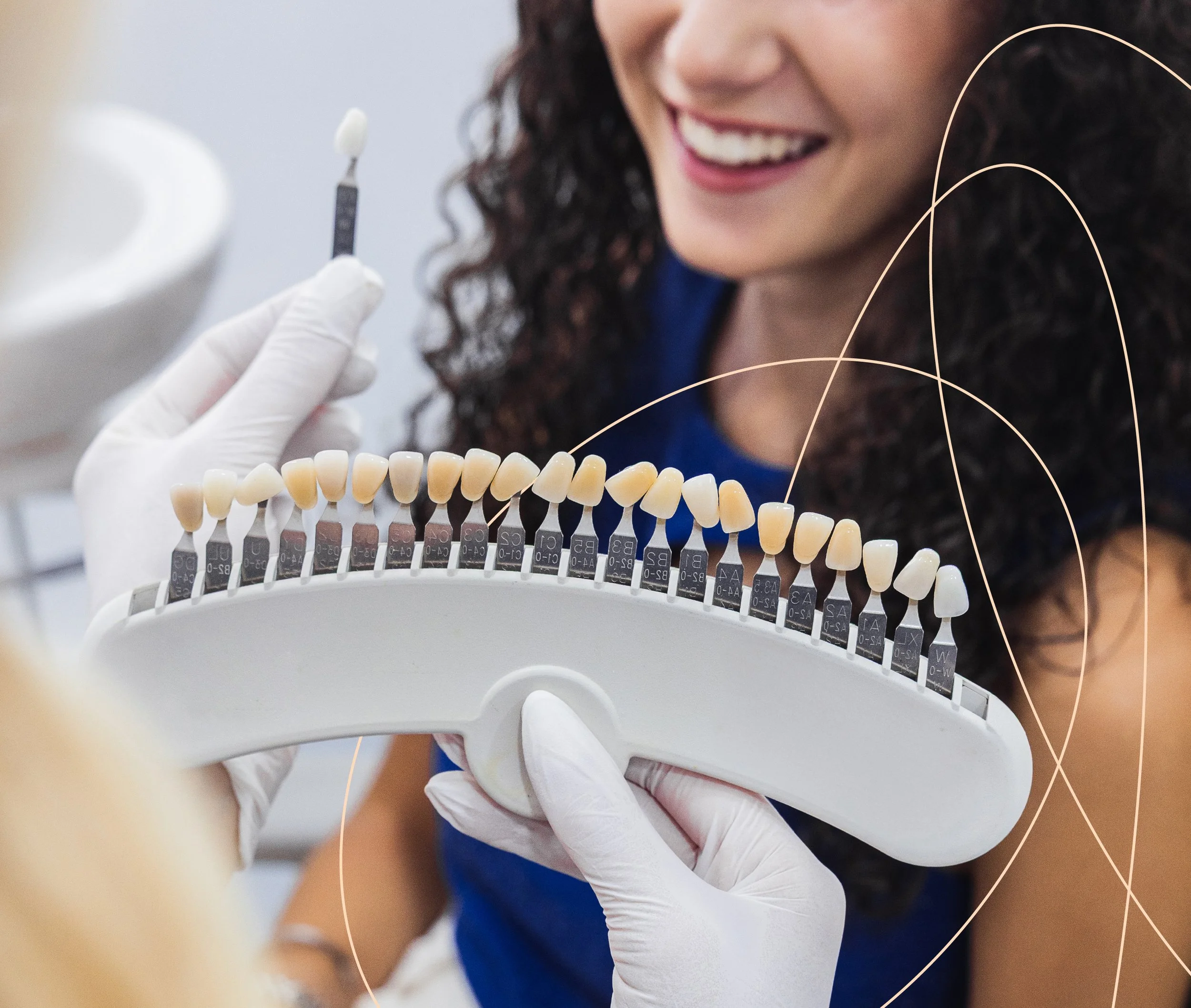 Dentist showing a shade guide with multiple tooth color samples to a patient in a dental office.