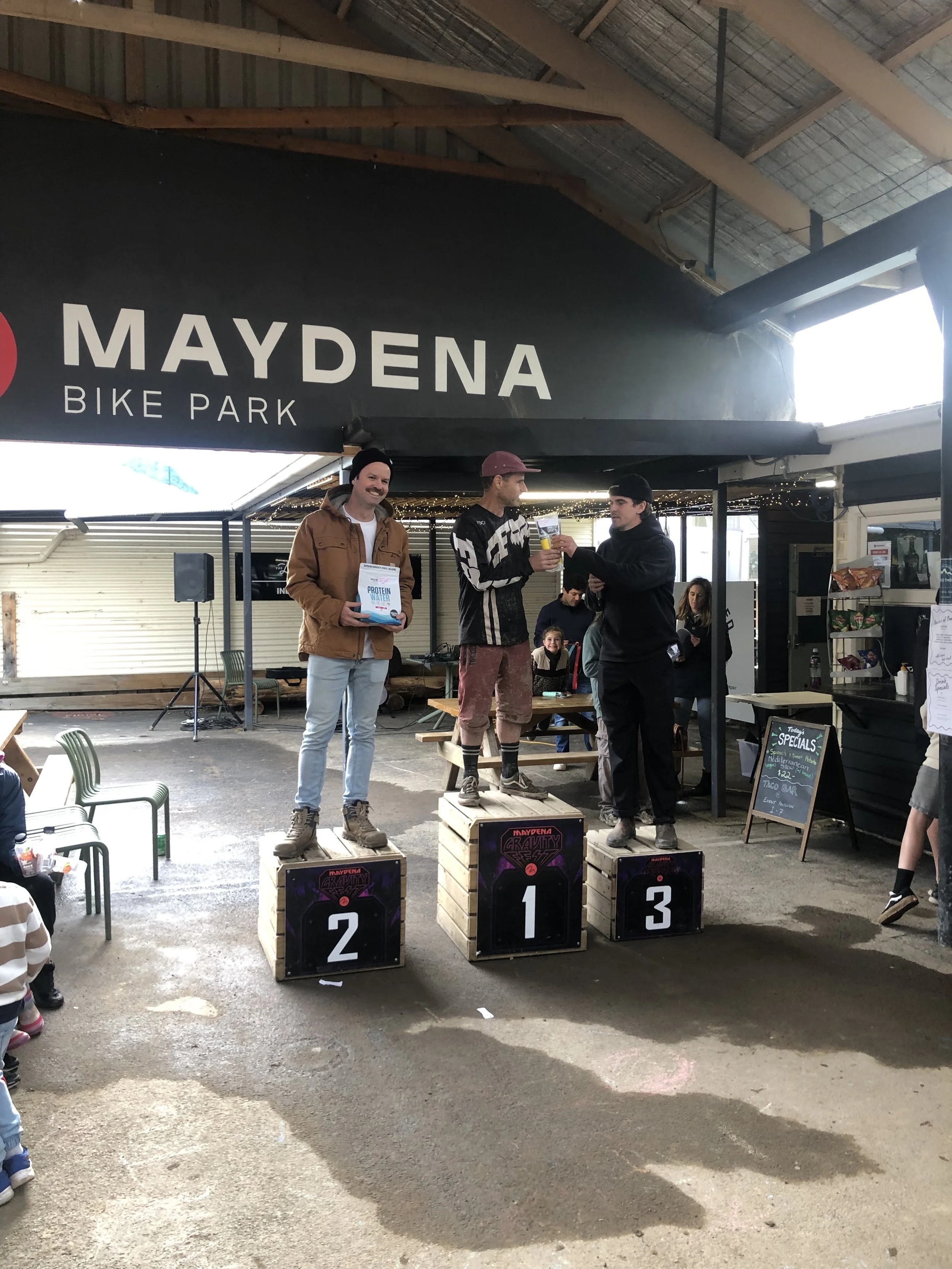 Nathan wins a downhill bike race against younger riders, representing Project Emerald’s “slow and steady” values.