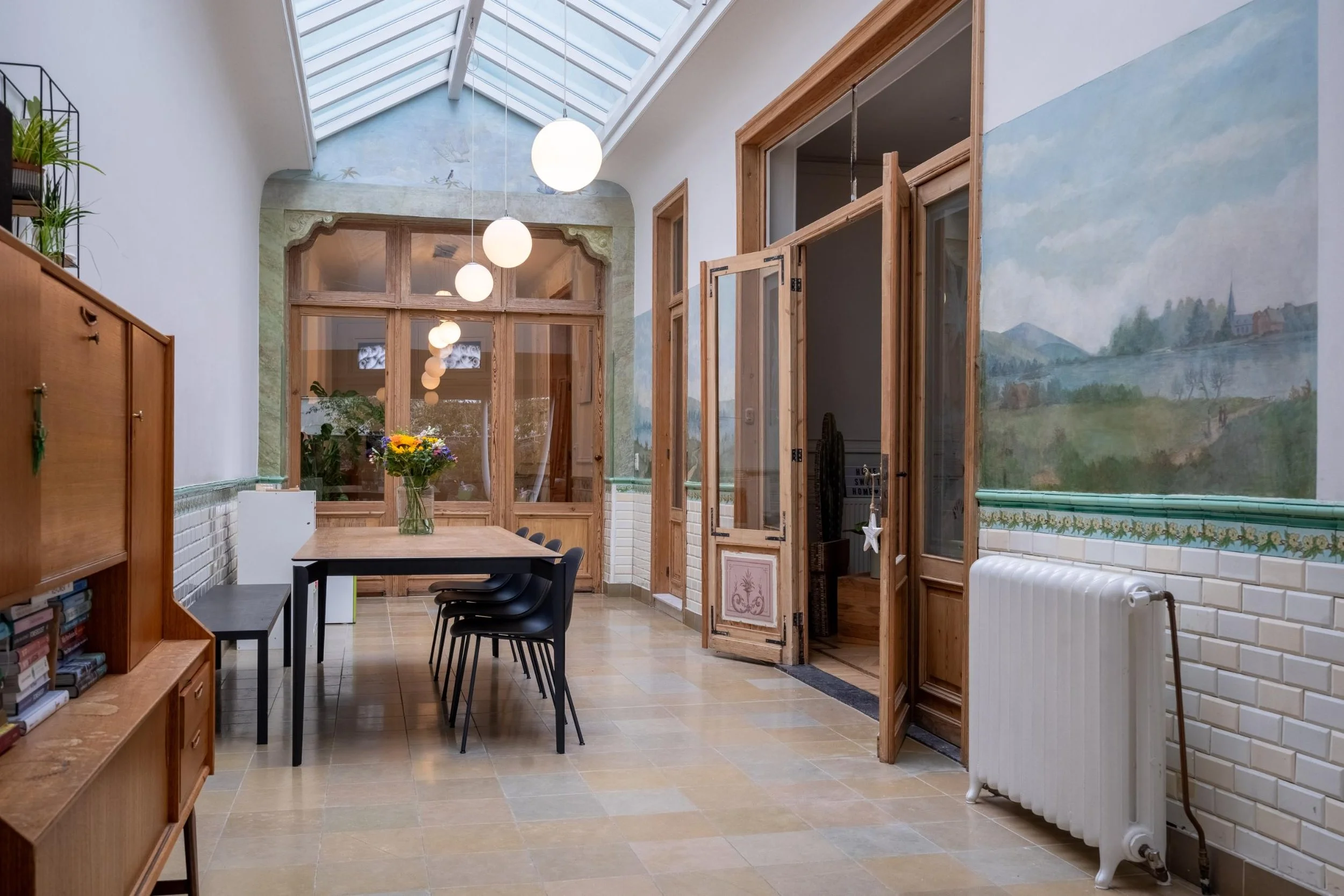 Een foto van een open eetruimte met veel lichtinval in Antwerpen