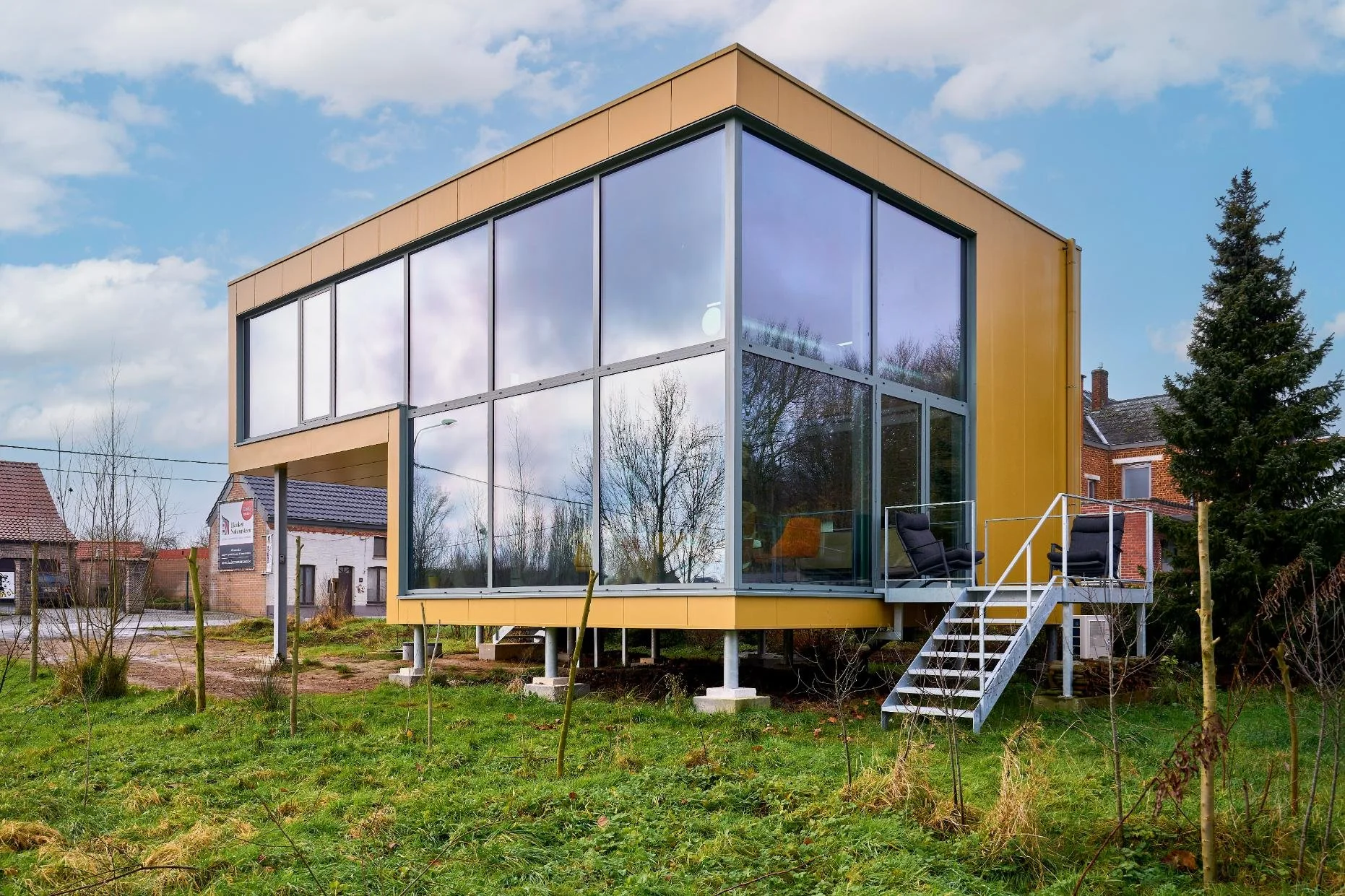 Een gevelfoto van een architectenwoning met uitgebreide beglazing in Brakel
