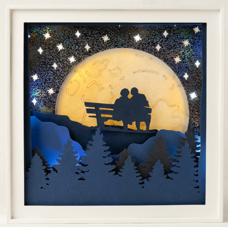 Silhouette of two people sitting on a bench under a large full moon, with a starry night sky and pine trees in the foreground.