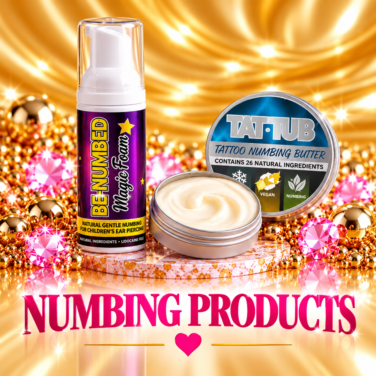 Close-up of a bottle of Benjumbed Magic Foam, a container of Tat-Tub tattoo numbing butter, and an open container of cream, set on a glittery surface with gold and pink decorations in the background. The text 'Numbing Products' is displayed at the bottom with a pink heart.