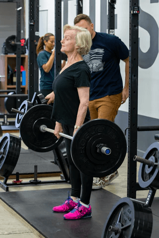 Senior women performing deadlifts to improve bone density in spine and hips.