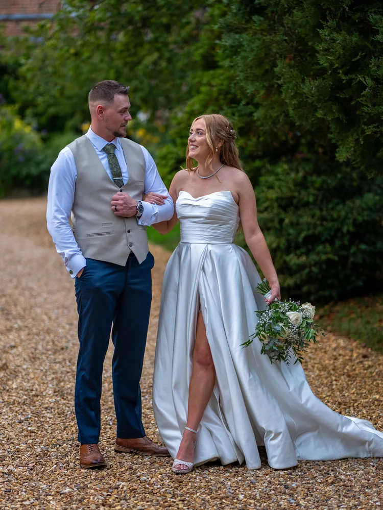 Groom laughing beside bride holding her bouquet