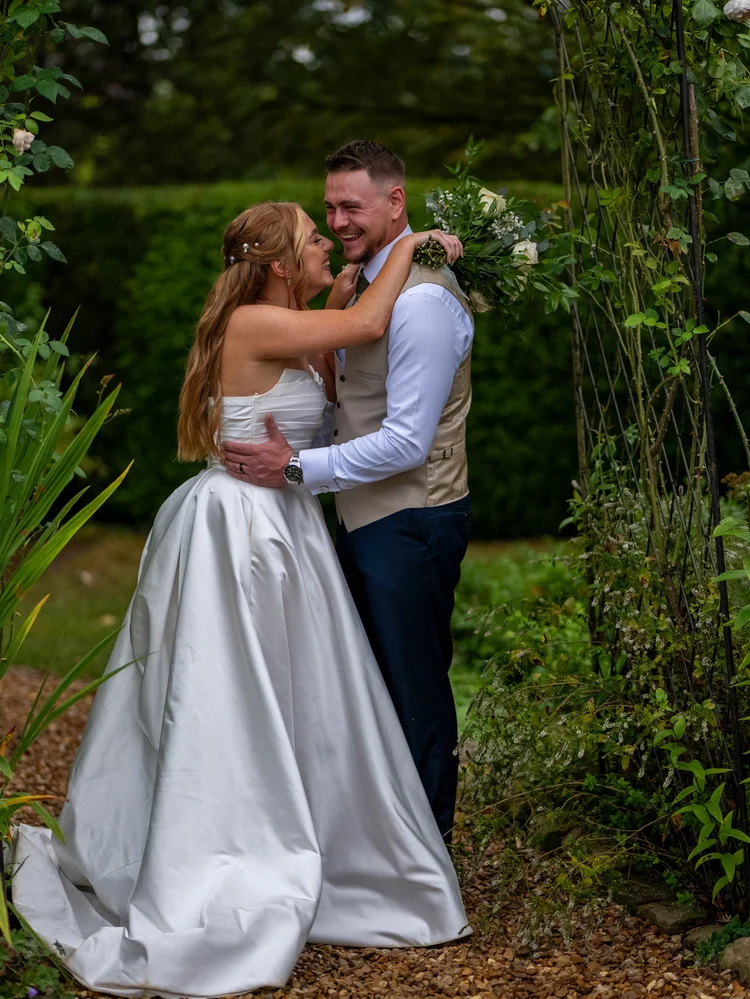 Bride and groom embracing in a garden