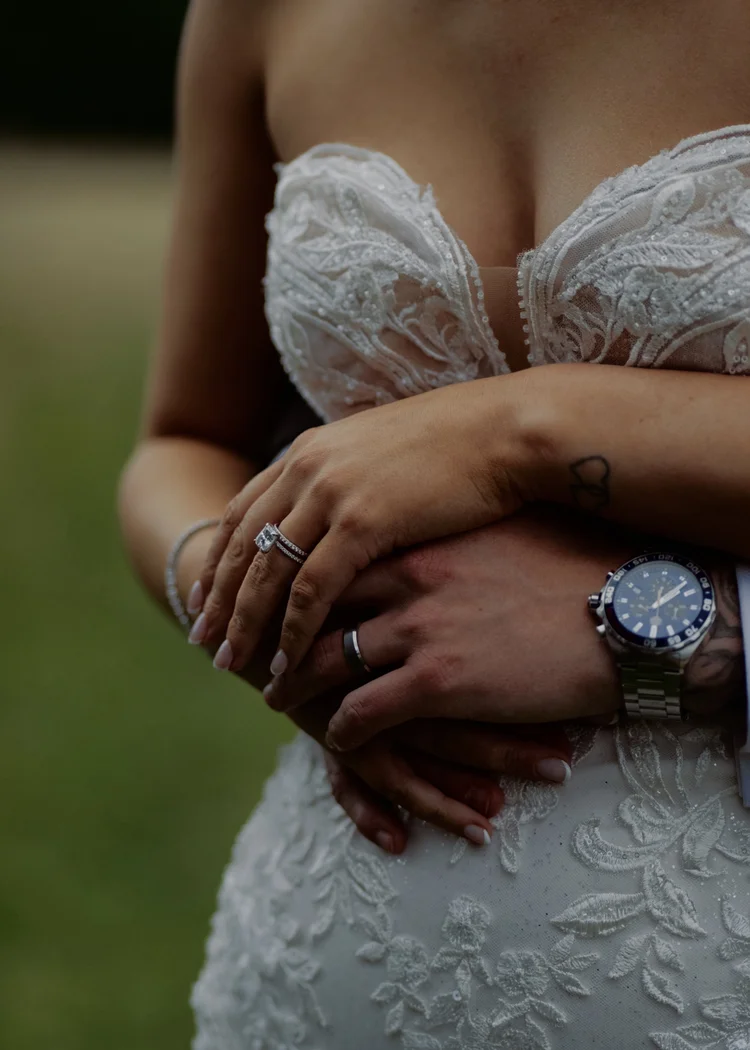 Close-up of bride and groom's hands showing wedding rings