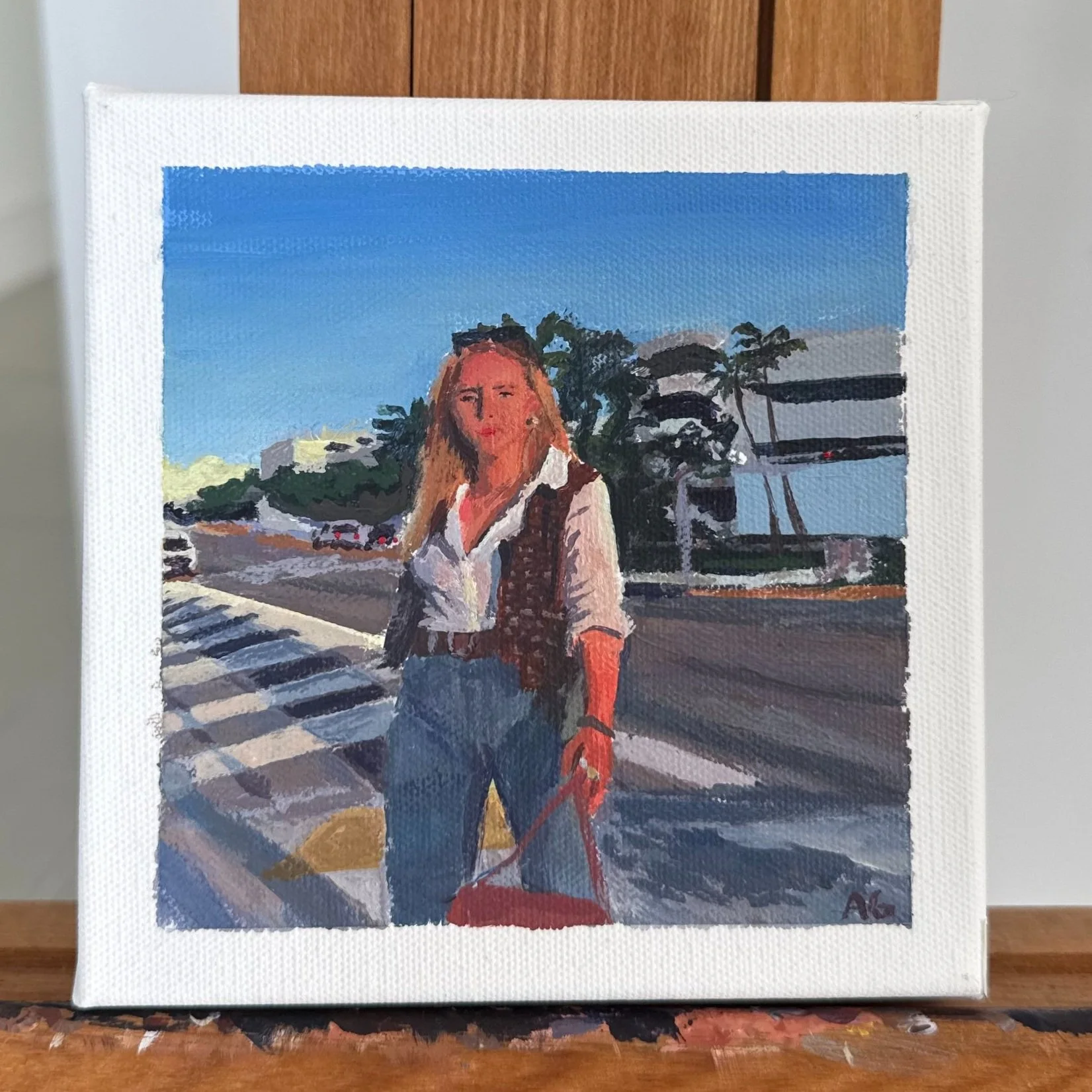 A painting of a woman with blonde hair, wearing a white shirt, jeans, and a vest, standing on a crosswalk near palm trees and modern buildings on a sunny day.