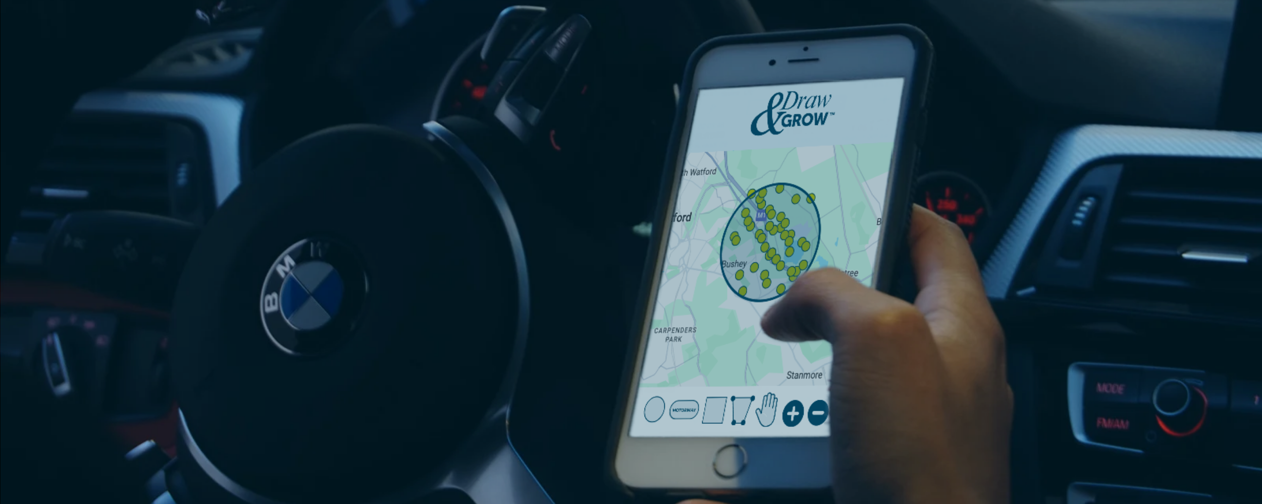 A person in a car holds a smartphone displaying a map with green dots inside a circle, related to a drawing app called Draw & Grow