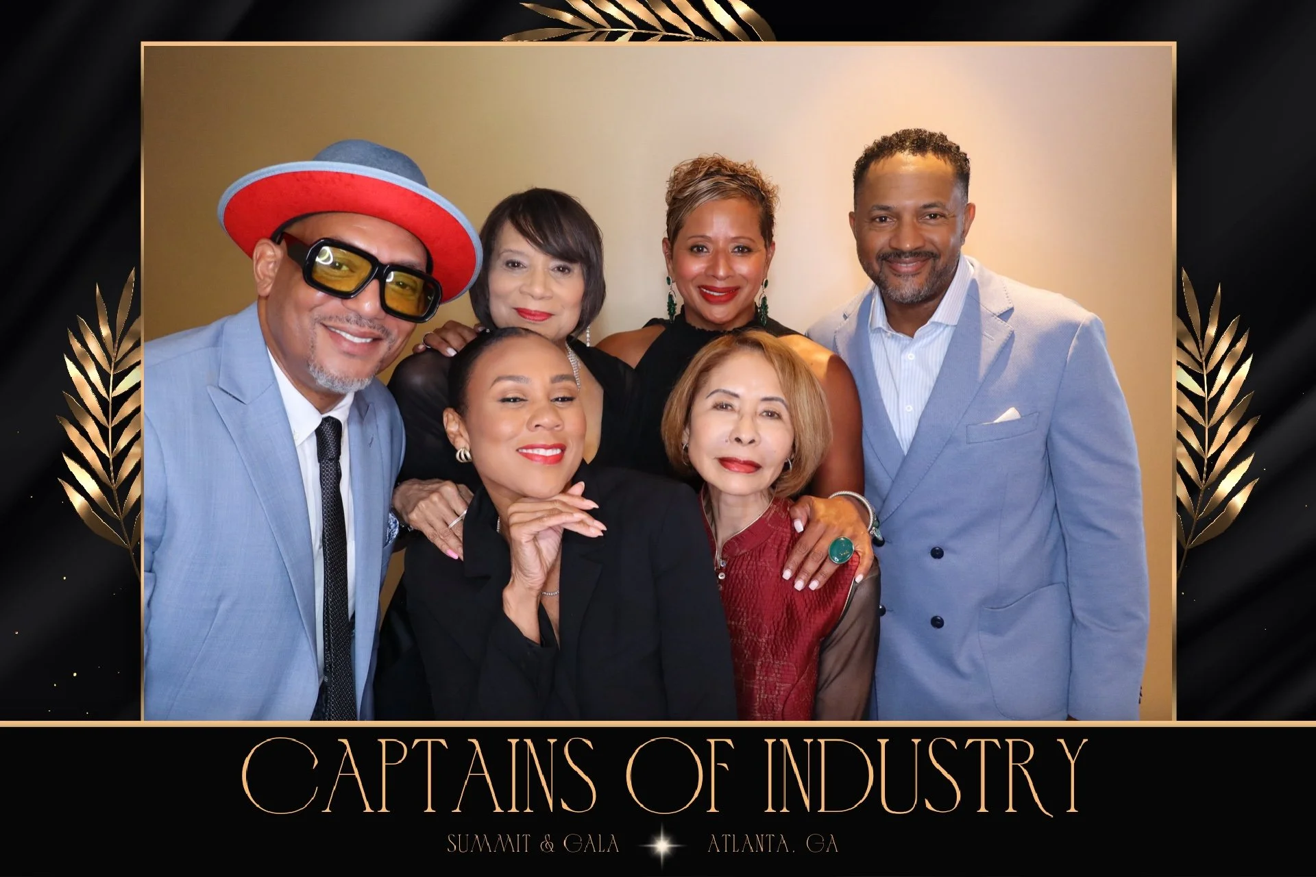 A group of seven diverse individuals dressed in formal attire, posing for a photo at the 'Captains of Industry' summit and gala in Atlanta, GA, with a black and gold decorative border and the event title below.