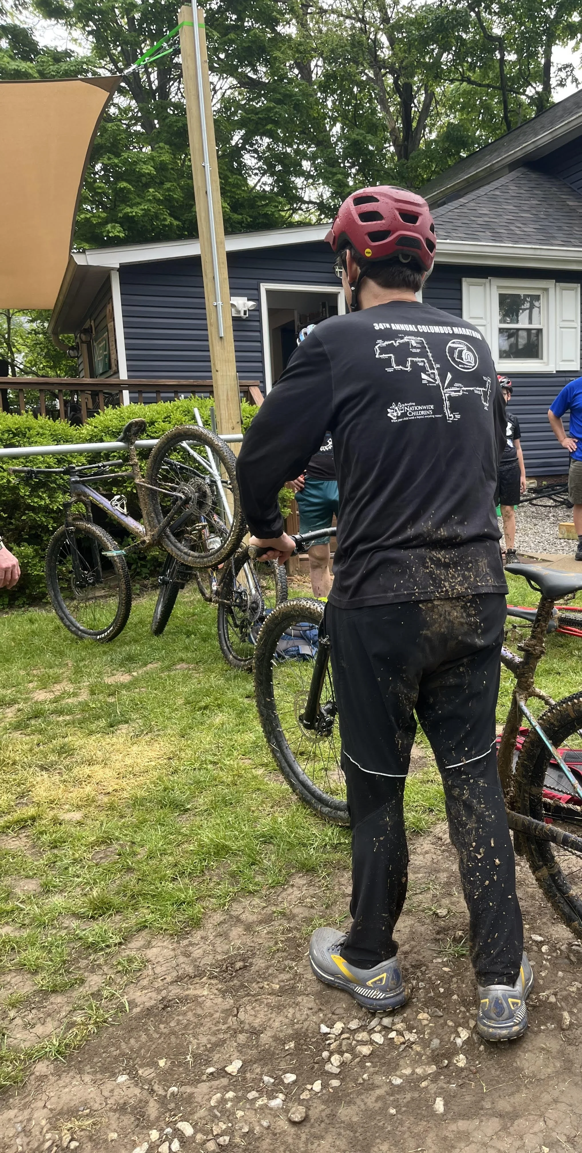 man standing with his bike photographed from behind