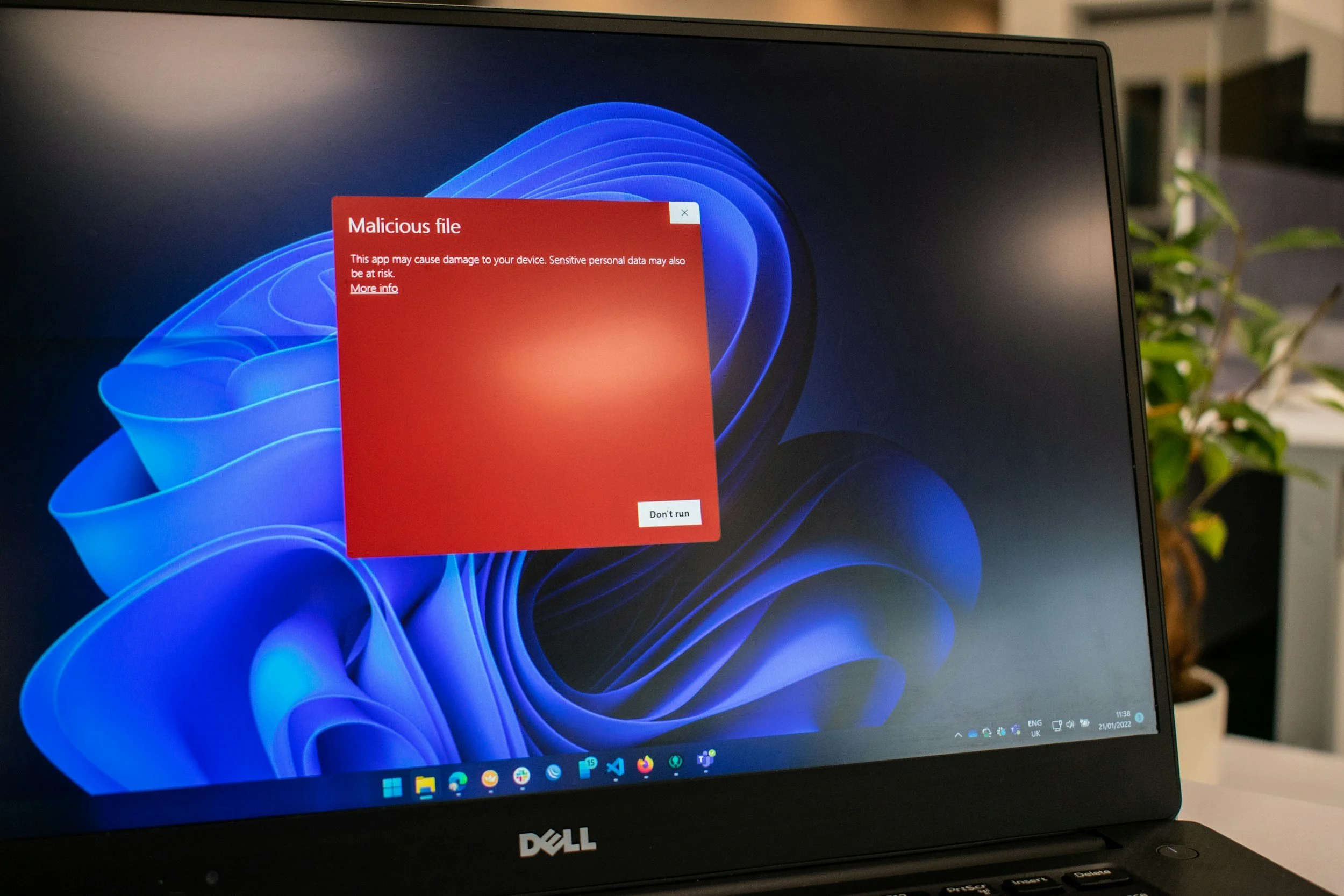 Laptop screen displaying a warning message about a malicious file with a red background and white text, titled 'Malicious file.'