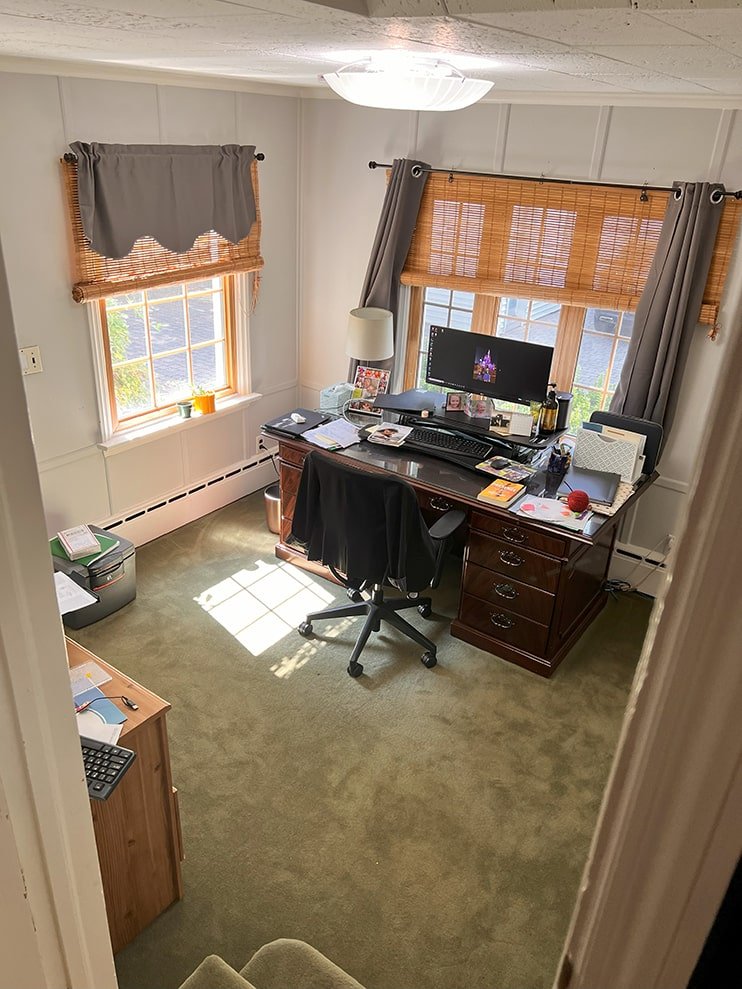 Home office with a desk, computer, office chair, lamp, and window blinds