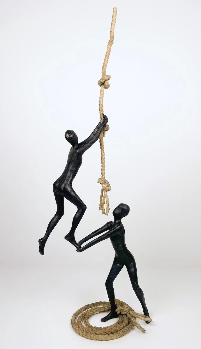 Tolla Support, two bronze figures, helping each other climb a bronze knotted rope