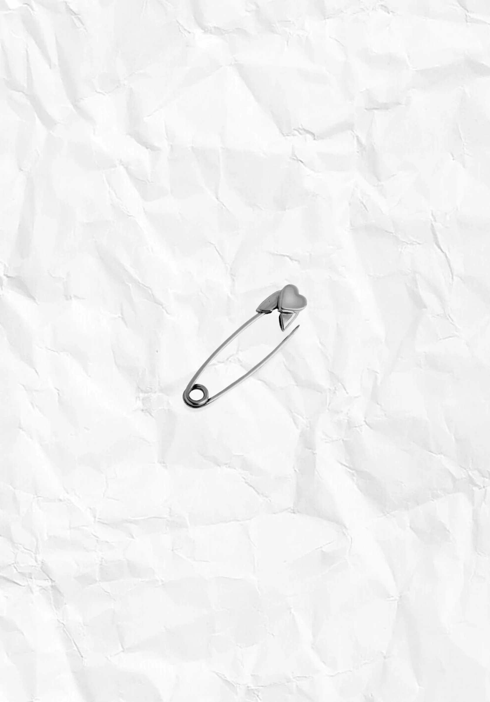 A silver heart-shaped safety pin tattoo design created by micro realism tattoo artist in Vienna