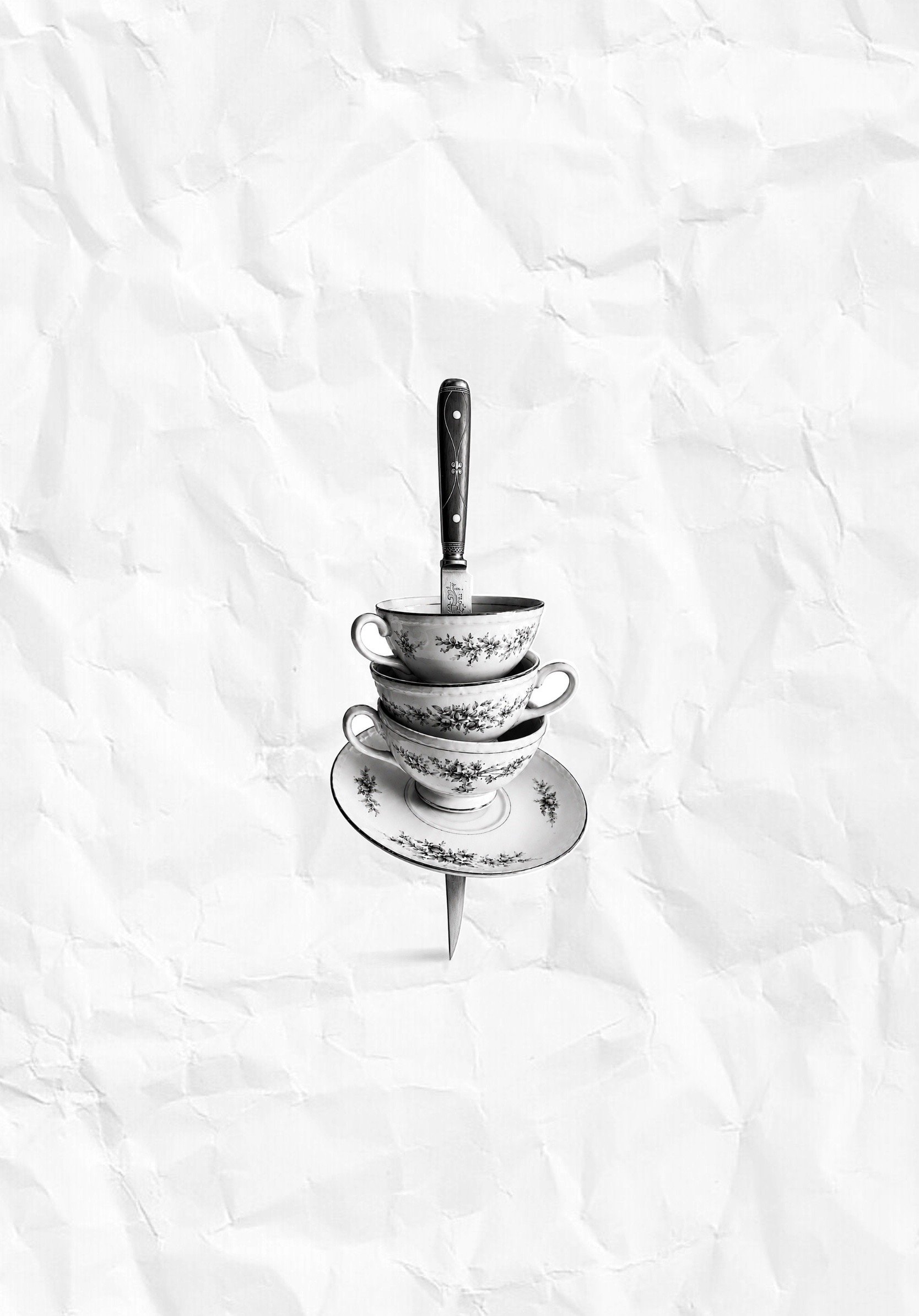 Micro realism tattoo project depicting stacked porcelain teacups with floral patterns pinned with a small knife with a black handle.