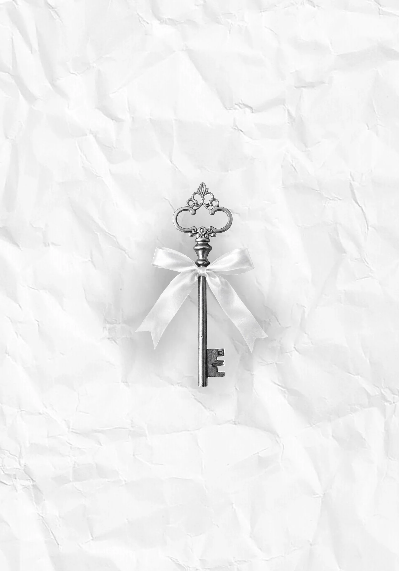 Micro-realistic tattoo design of an antique key adorned with a soft satin ribbon.