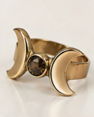 Brass triple moon ring with dark gemstone, angled view