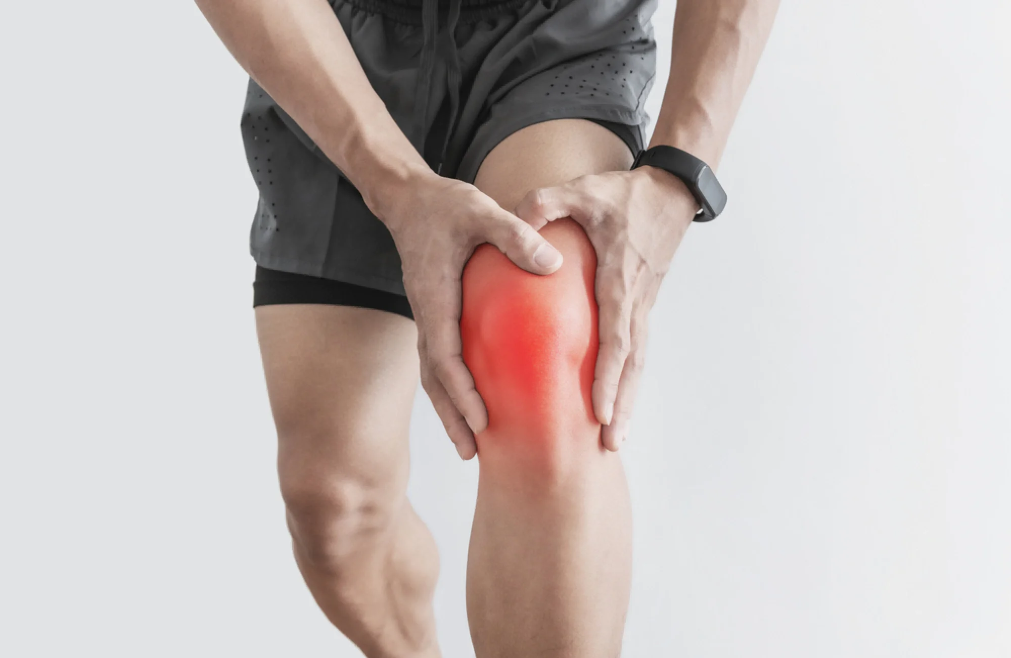 man holding knee in pain while being active