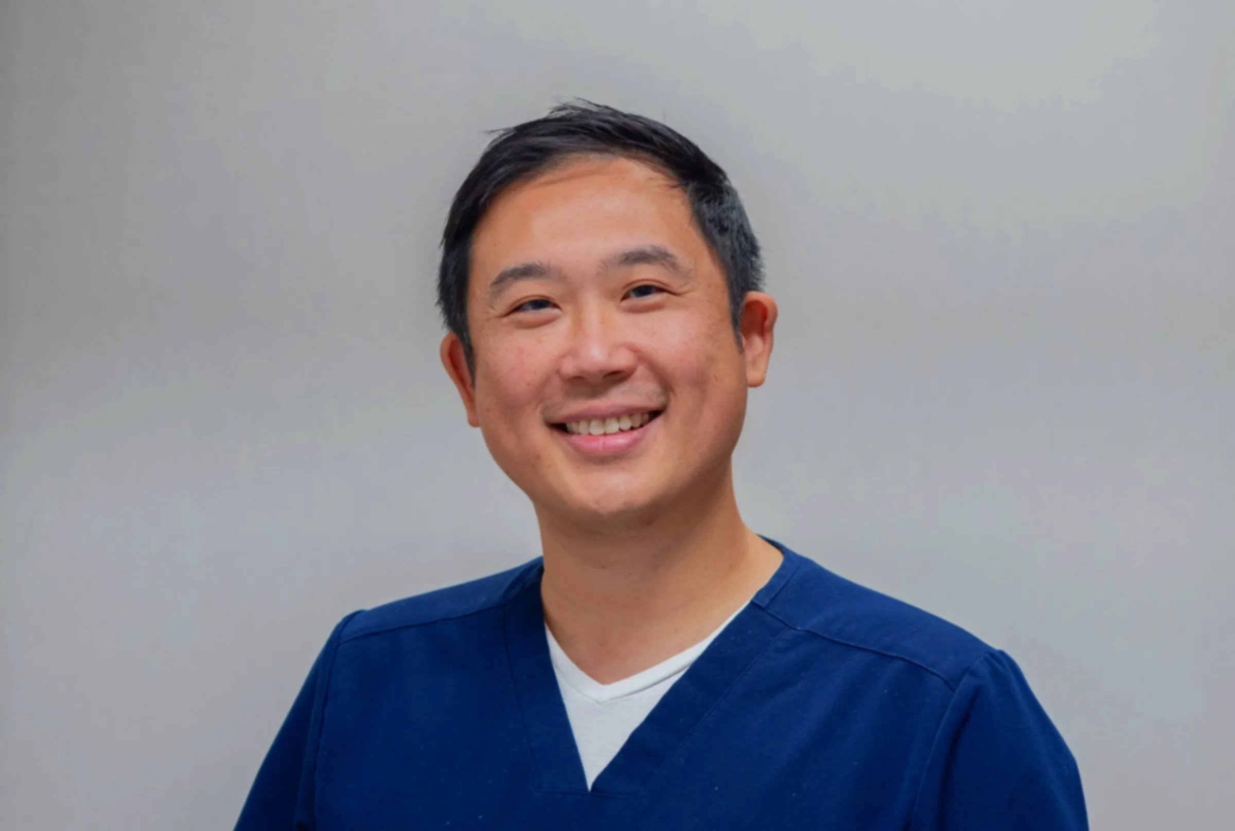 Doctor Peng Bai smiling taking a headshot for Resolution Spine and Joints website