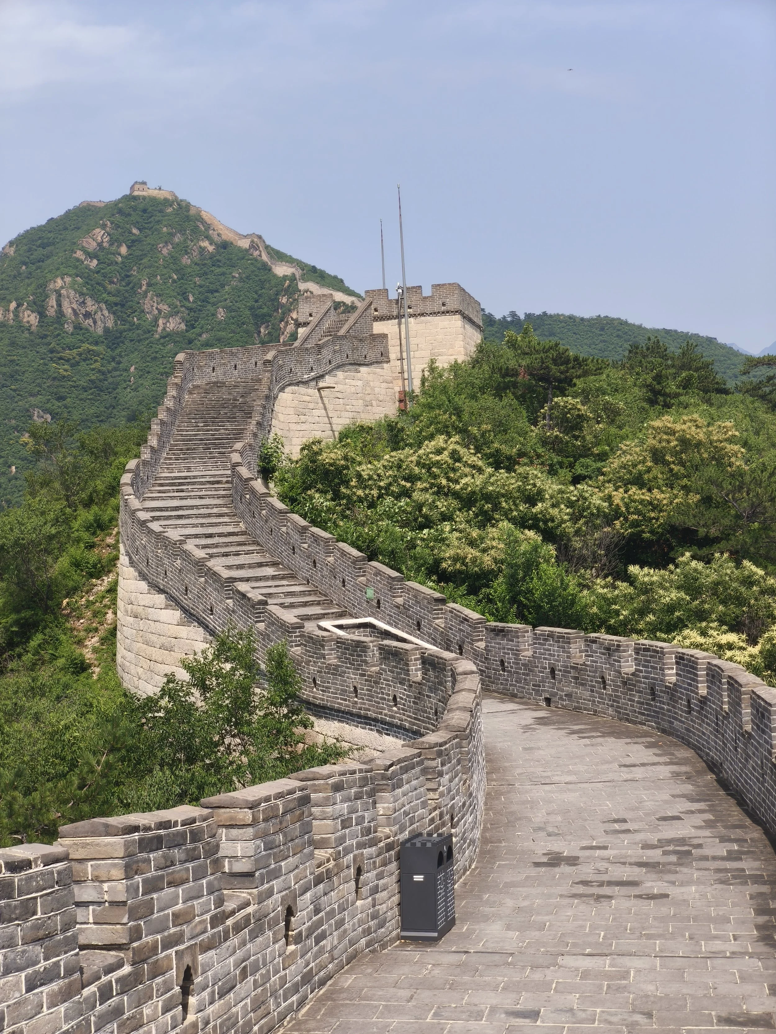 The Great Wall of China extending over green hills under a blue sky.