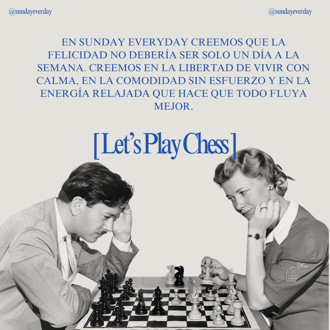 A black and white image of a man and woman playing chess, both appear focused on the game, with the woman holding a chess piece.
