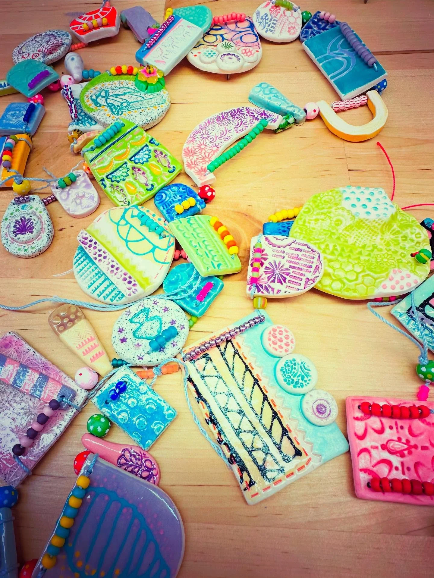 A garland in a pile! All done just adding final little touches. It's 6 feet long. Now I just need to find a wall for it. Stay tuned...🩷💜💙. #ceramic #ceramicart #jeweler #clay #wip