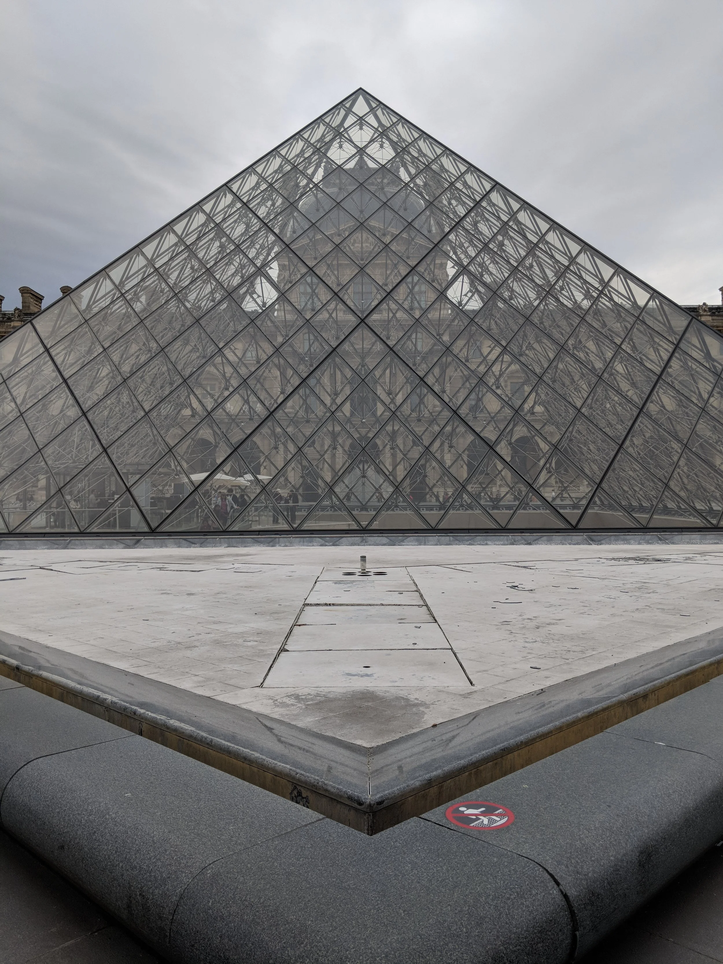 Front view of the glass pyramid structure at the entrance of the Louvre Museum in Paris, France.