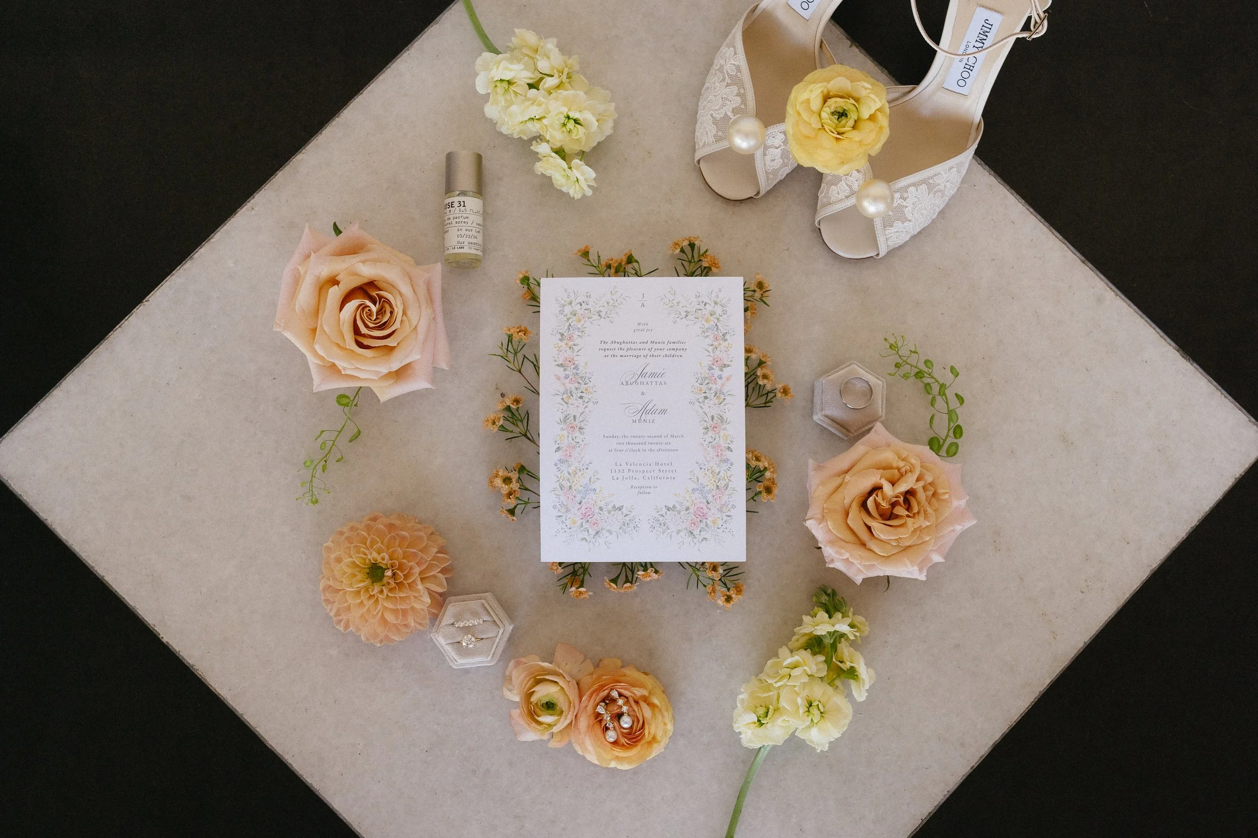Classic bridal flat lay details with florals on black and white floor tiles