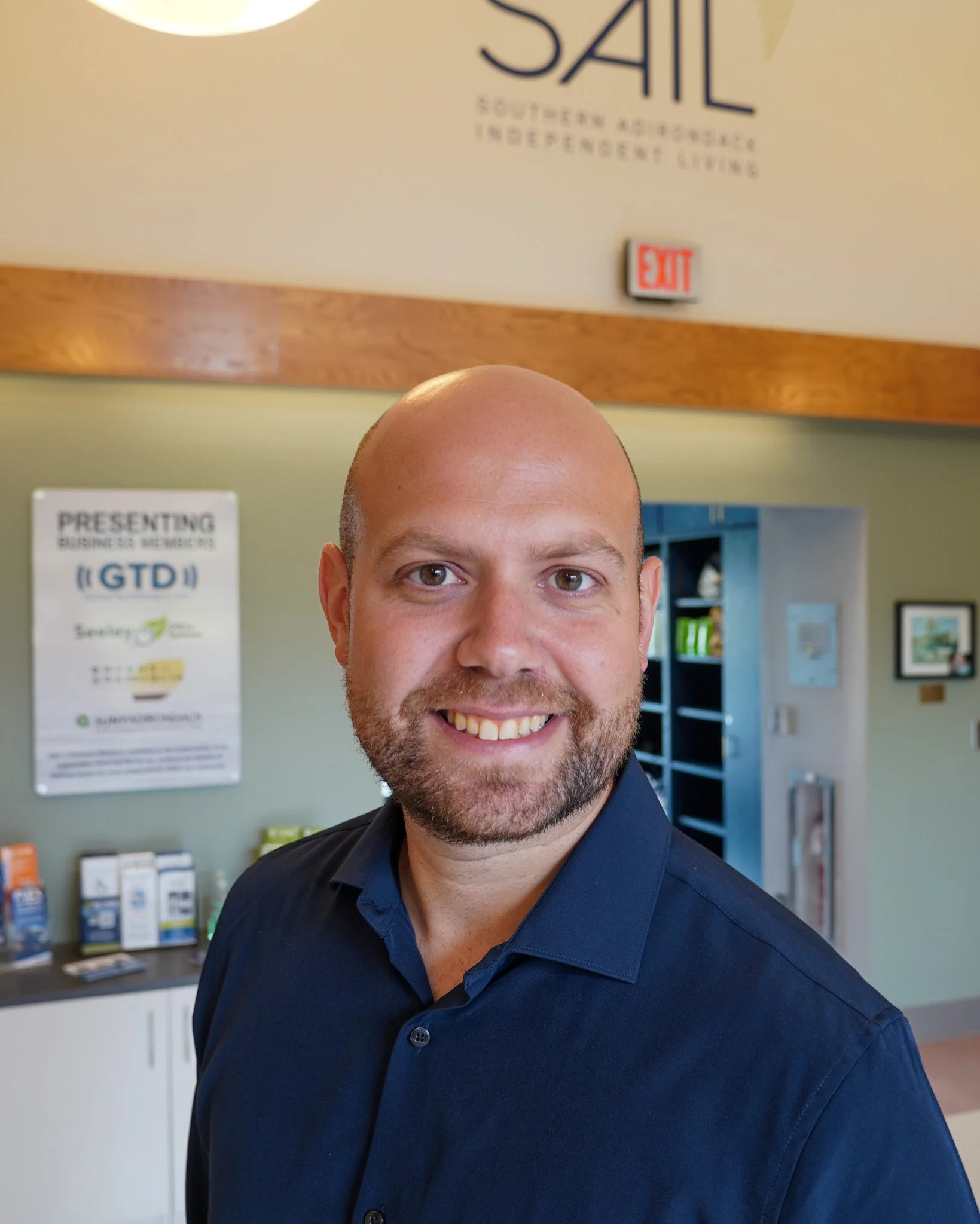 Photo of Tyler Whitney, smiling, with a lobby in the background