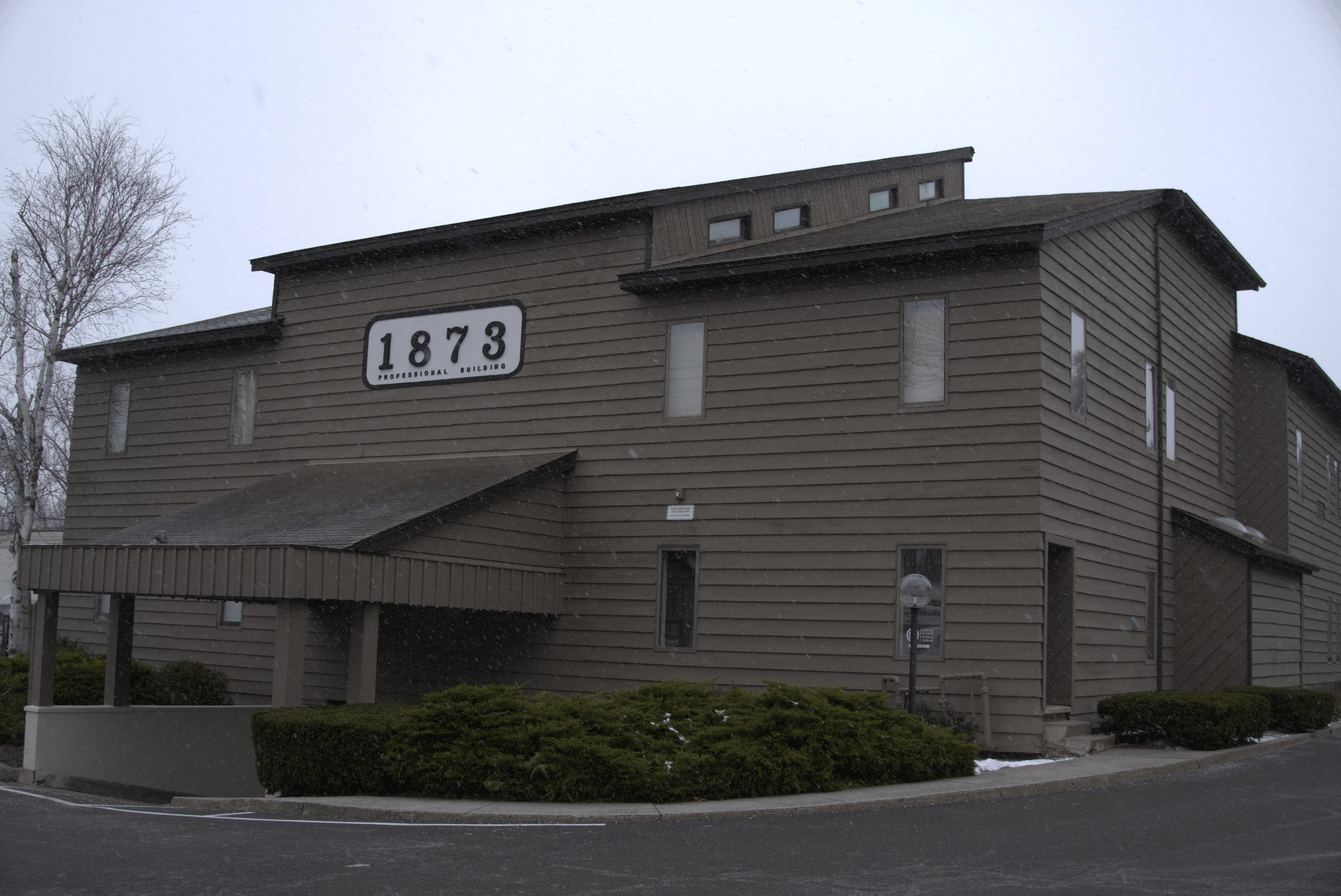 Photo of brown building with a sign that says 1873 Professional Building