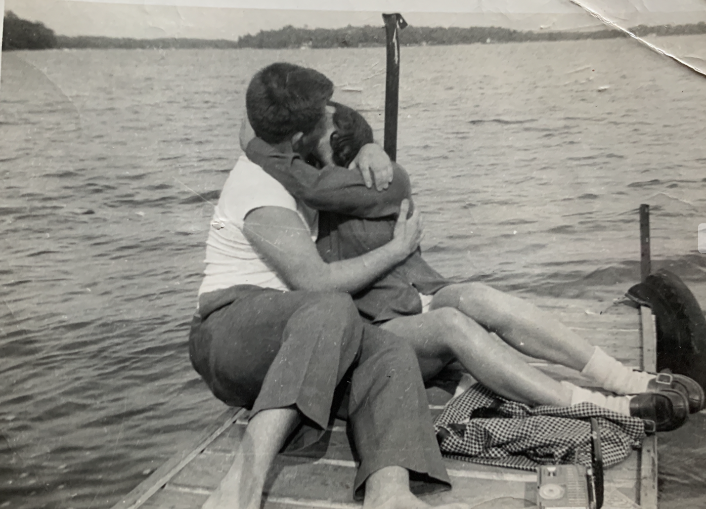 An old black and white photo of two people on a dock