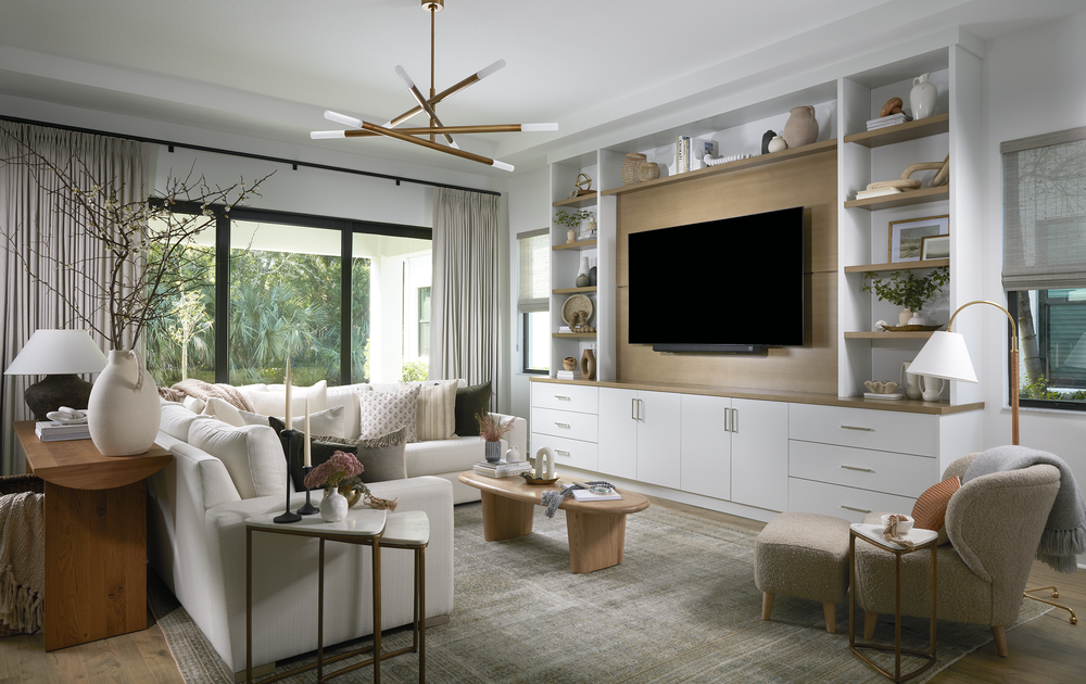 Living room with a white sectional, wood coffee table, and built-in bookshelves