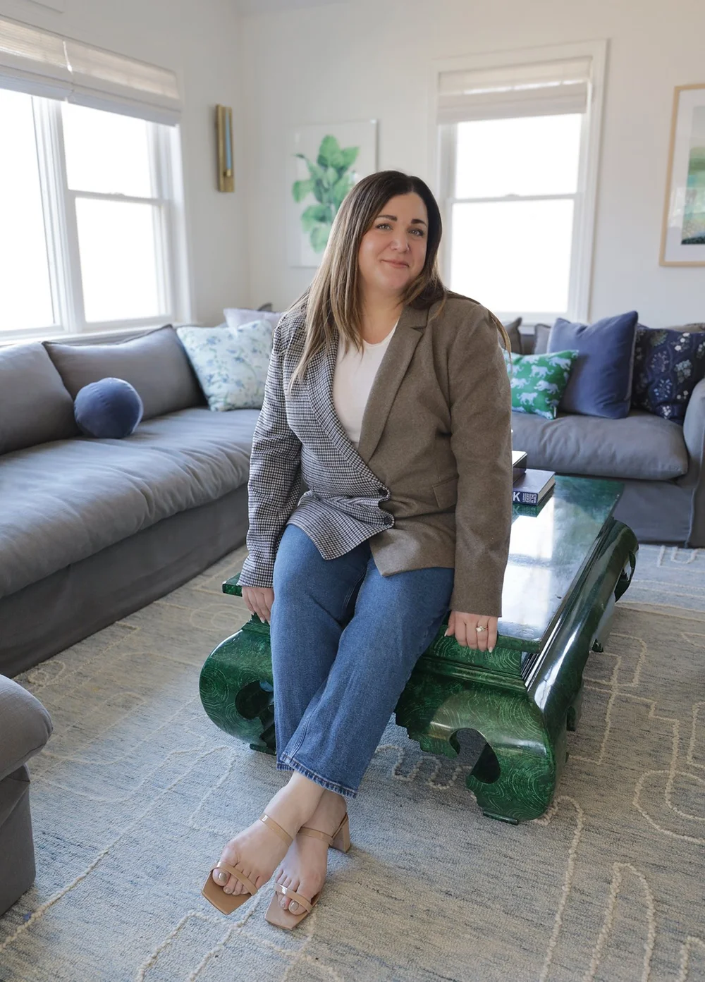 Leah Weinberg, founder and principal designer of Leah Weinberg Design, seated in a living room