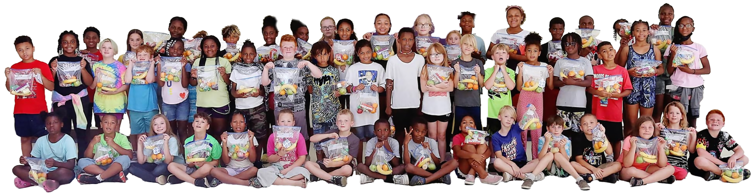 Group of children holding goodie bags, some standing and some sitting, in a classroom setting.