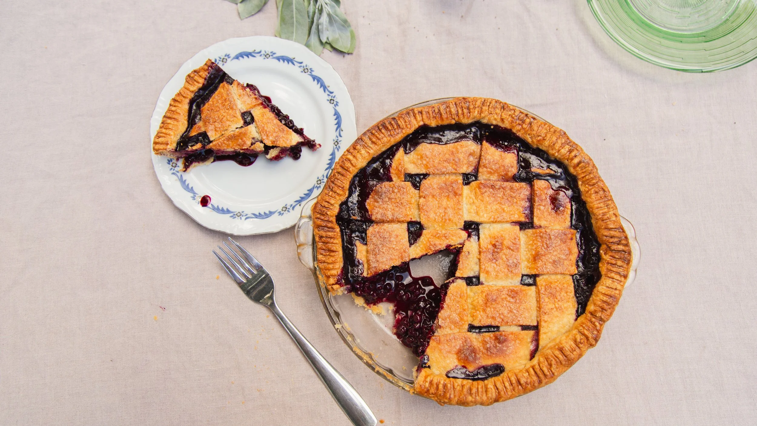 Homemade lattice berry pie with a slice served on a vintage blue floral plate