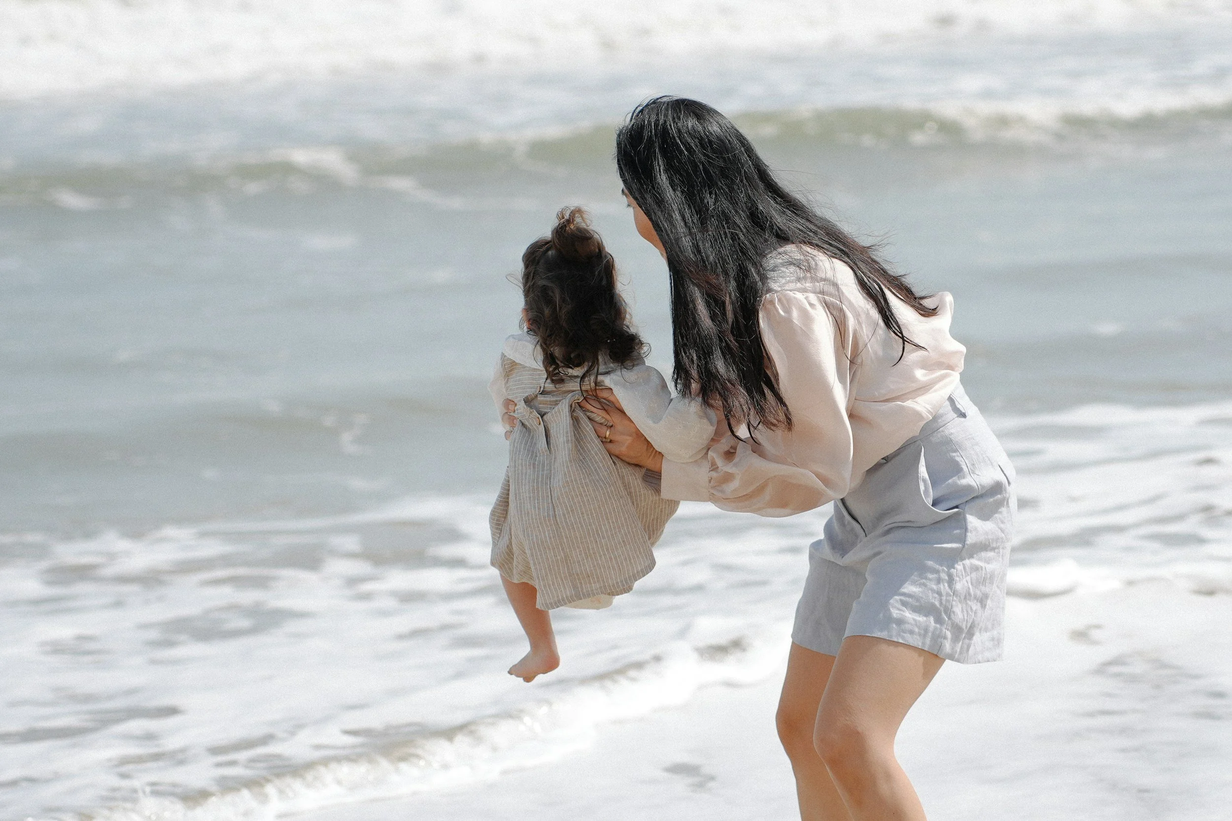 A woman holding a young girl at the beach feeling calm after utilizing SPACE treatment in Tampa, FL